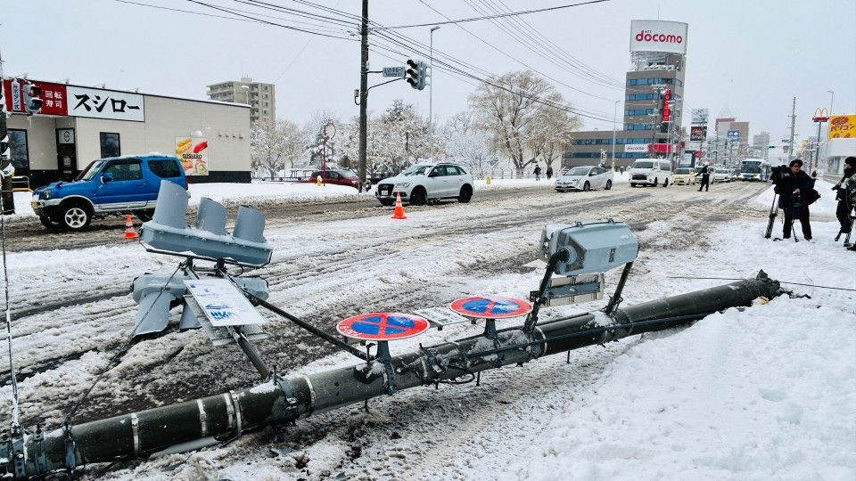 道路を塞ぐ折れた信号機の柱